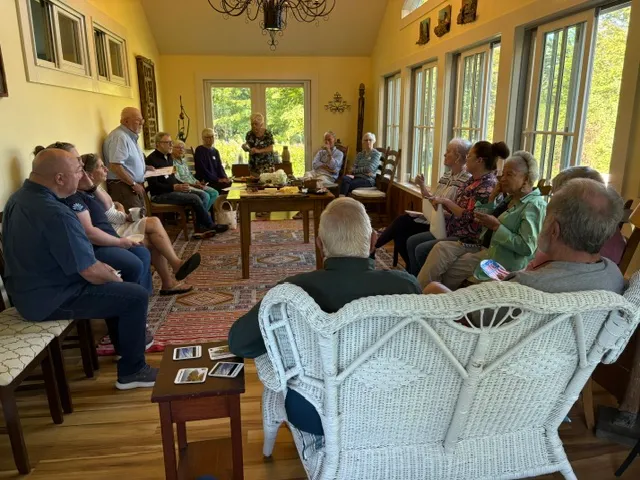 A living room full of seated guests listening during a campaign gathering